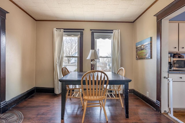 dining space with baseboards, dark wood finished floors, and ornamental molding