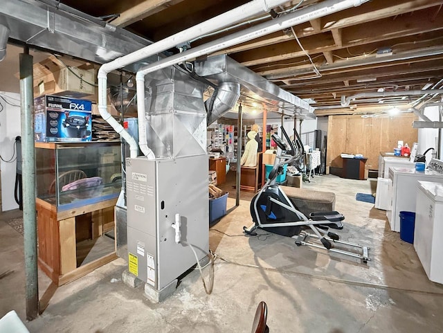 unfinished basement featuring washer and clothes dryer and heating unit