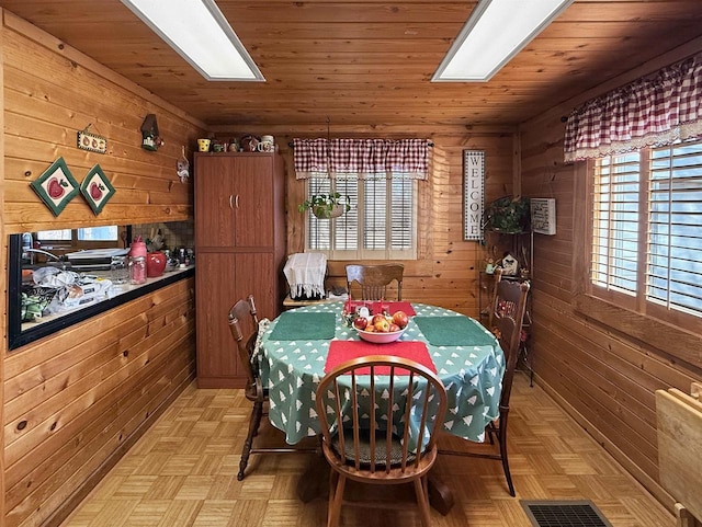 dining space featuring visible vents, wood walls, and wood ceiling