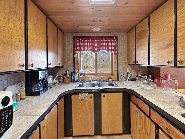 kitchen with tile counters, wood ceiling, and a sink