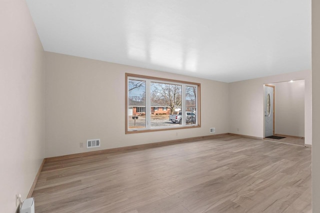 unfurnished room with visible vents, baseboards, and light wood-style flooring