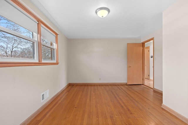 spare room with visible vents, baseboards, and light wood-style flooring