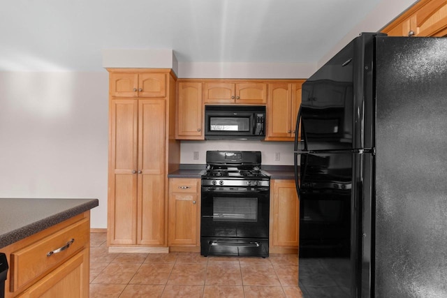 kitchen with light tile patterned floors, dark countertops, and black appliances