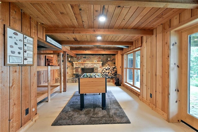 rec room with beam ceiling, wooden walls, a healthy amount of sunlight, and wooden ceiling