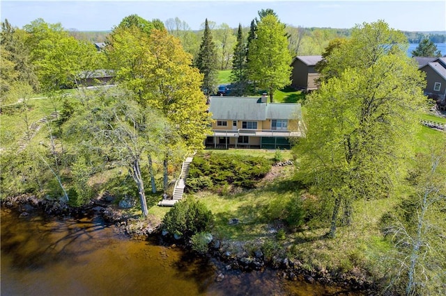 aerial view with a water view and a wooded view