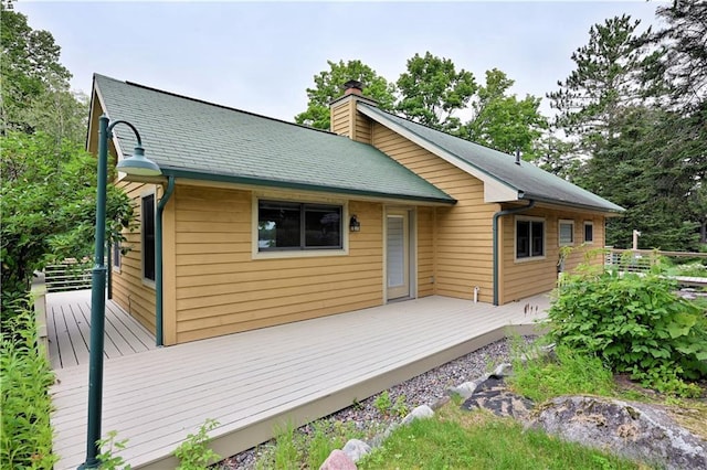 back of house featuring a chimney and a deck