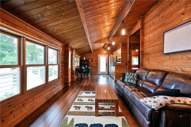 unfurnished living room featuring a wealth of natural light, lofted ceiling with beams, hardwood / wood-style floors, wooden walls, and wood ceiling