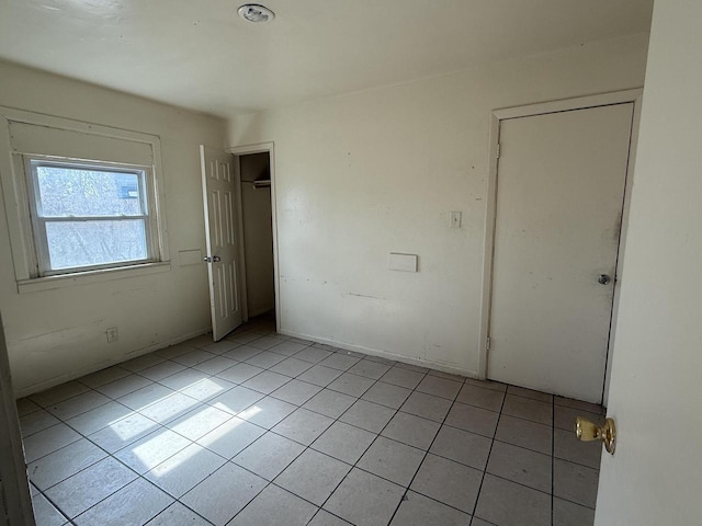 unfurnished bedroom featuring light tile patterned floors and a closet