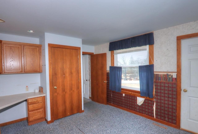 interior space with a closet, carpet, and built in study area