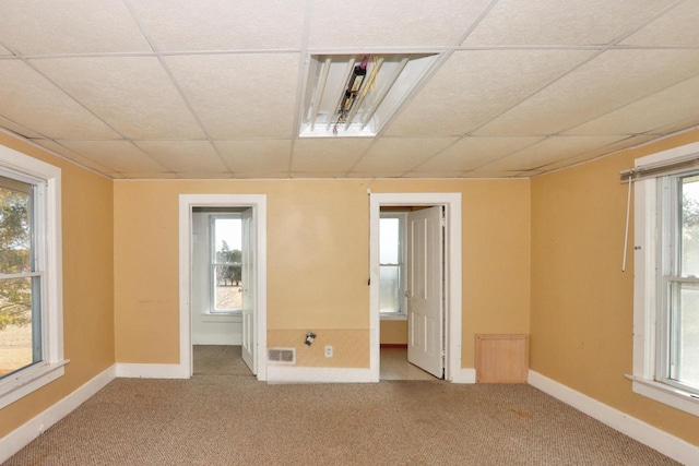 spare room with baseboards, a paneled ceiling, and carpet floors