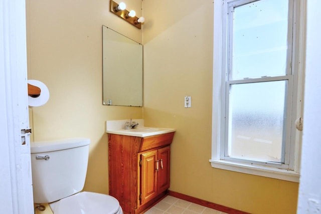 bathroom with vanity, toilet, and baseboards