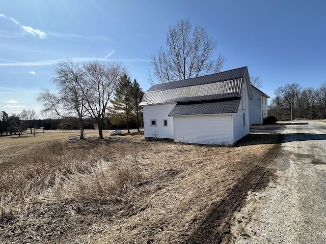 view of home's exterior featuring a gambrel roof and metal roof