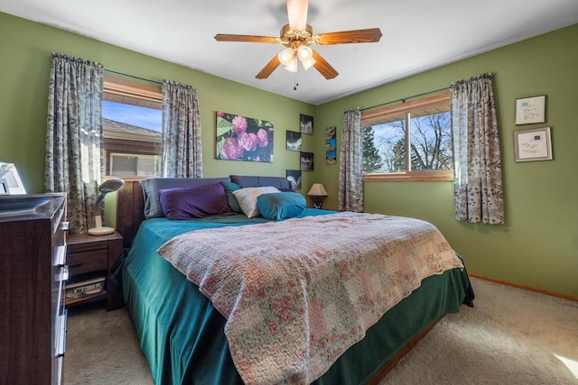 bedroom featuring light colored carpet, baseboards, and ceiling fan