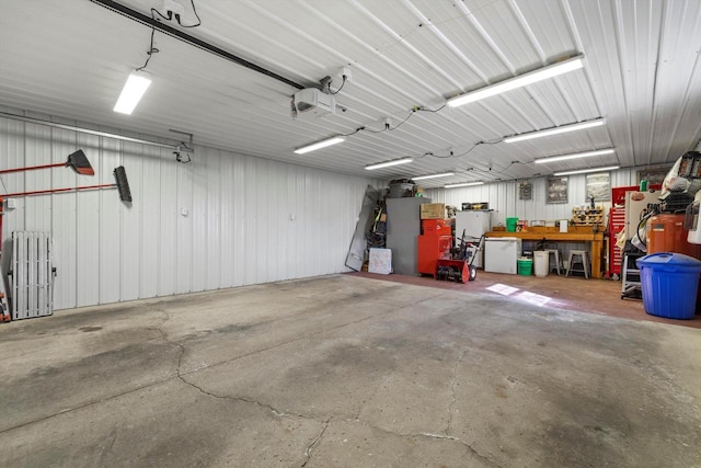 garage with a workshop area, radiator, and metal wall