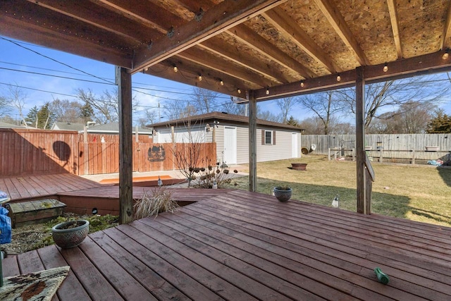 wooden terrace with an outbuilding, a yard, and a fenced backyard