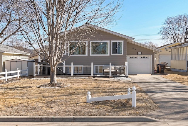 view of front of home featuring an attached garage, driveway, and fence