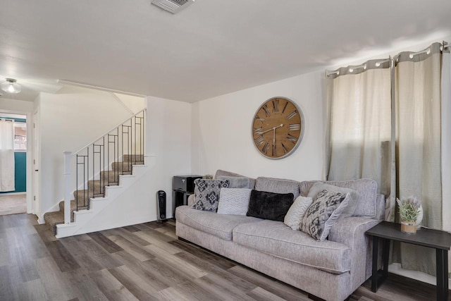 living area featuring visible vents, stairs, and wood finished floors