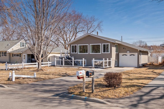 view of front of house featuring driveway, an attached garage, and fence