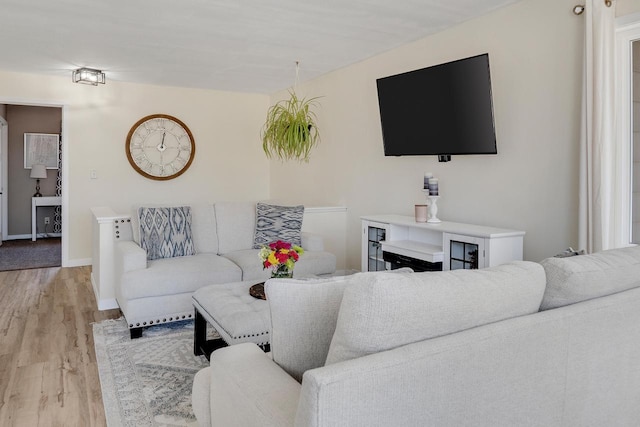 living area with light wood-style flooring and baseboards