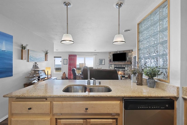 kitchen featuring visible vents, a sink, open floor plan, a stone fireplace, and dishwasher