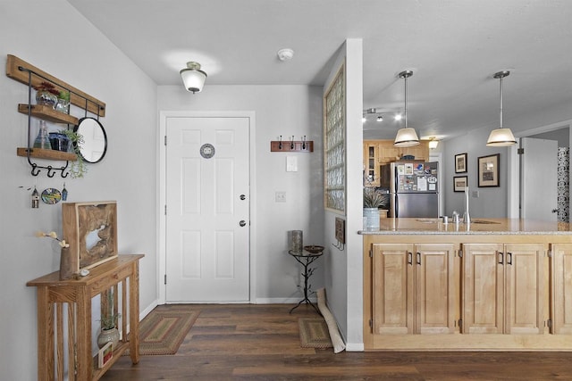 foyer featuring baseboards and dark wood-type flooring