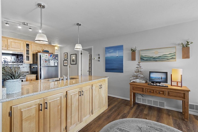 kitchen with glass insert cabinets, light brown cabinetry, dark wood-style flooring, freestanding refrigerator, and a sink