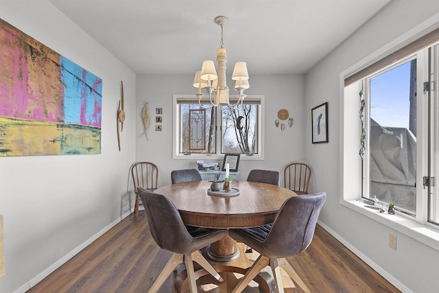 dining space featuring baseboards, dark wood-type flooring, and a notable chandelier