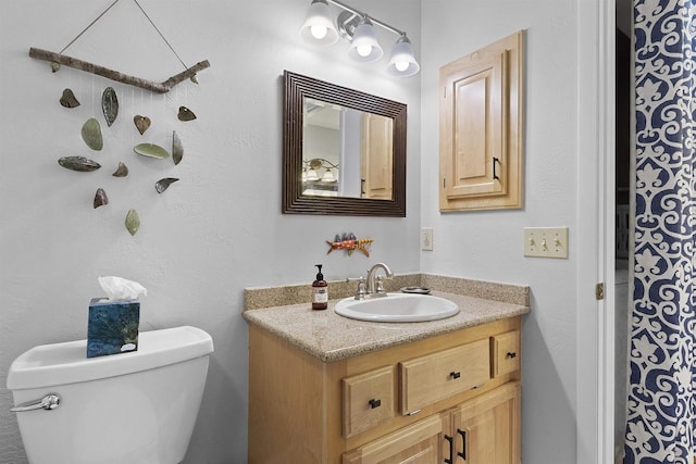 full bathroom with toilet and vanity