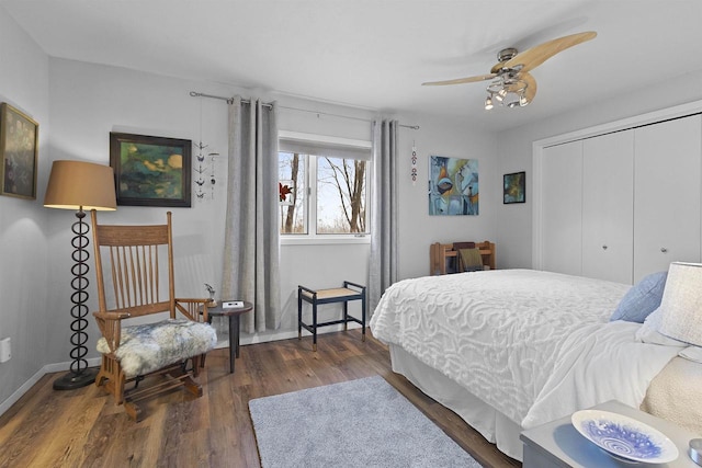 bedroom with ceiling fan, wood finished floors, a closet, and baseboards