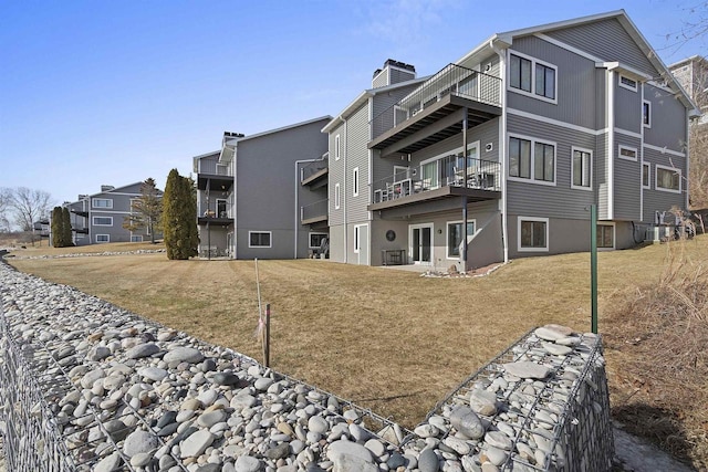 exterior space with central AC unit and a lawn