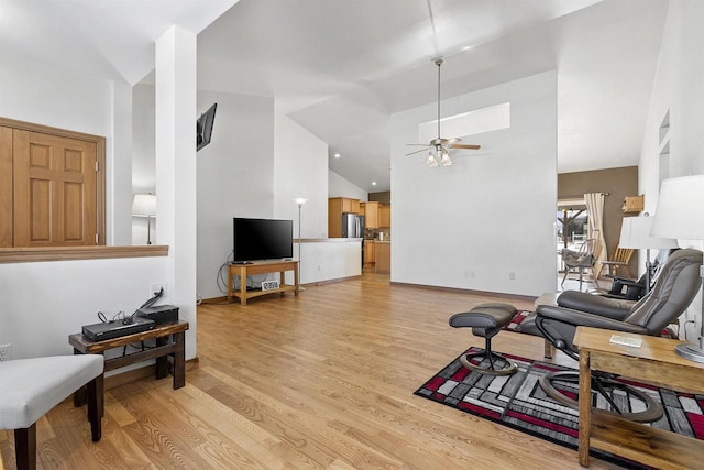 living area with high vaulted ceiling, light wood-style floors, and a ceiling fan