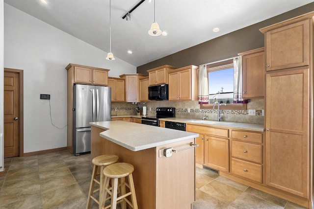 kitchen featuring a center island, light countertops, decorative backsplash, black appliances, and a sink