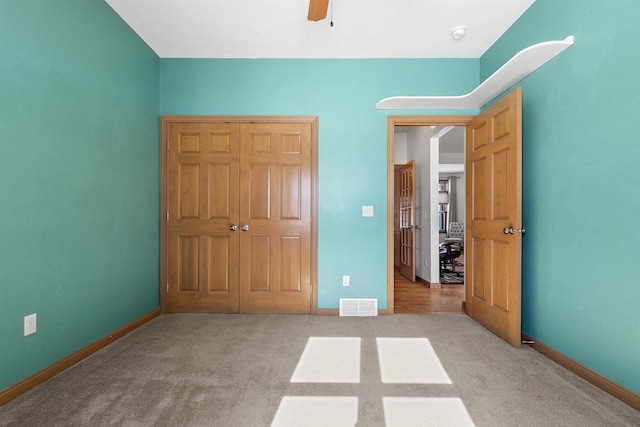 unfurnished bedroom featuring visible vents, carpet flooring, and baseboards