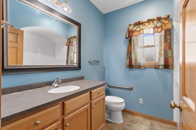 bathroom with vanity, toilet, and baseboards