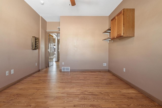 spare room with light wood-style flooring, baseboards, visible vents, and ceiling fan