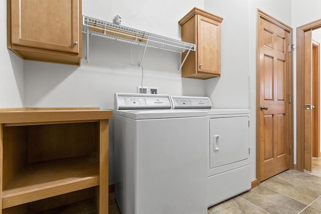 laundry room with washer and dryer, cabinet space, and light tile patterned floors