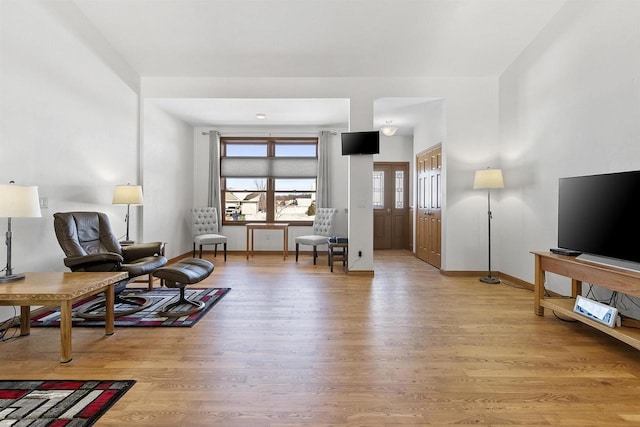 sitting room with baseboards and light wood-type flooring