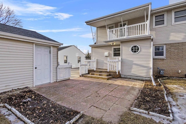 rear view of house with a balcony and a patio