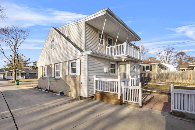 view of front of property with a balcony and fence