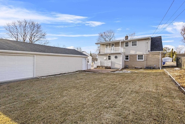 rear view of house featuring central AC unit, a chimney, a yard, a garage, and a balcony