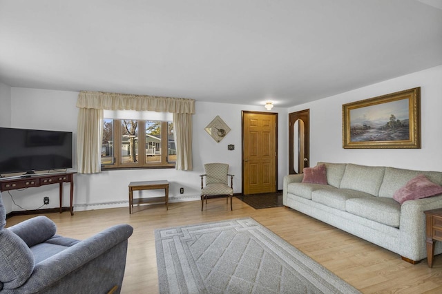 living area featuring baseboards and wood finished floors