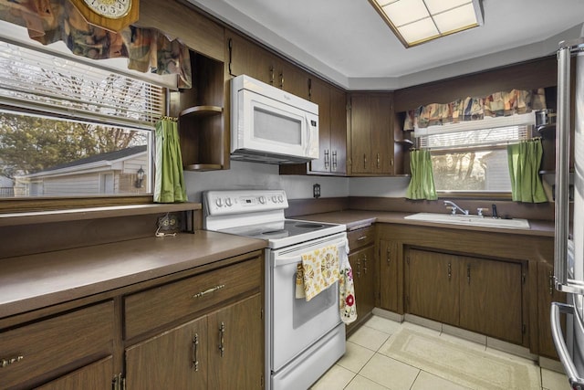 kitchen with a sink, open shelves, white appliances, and light tile patterned floors