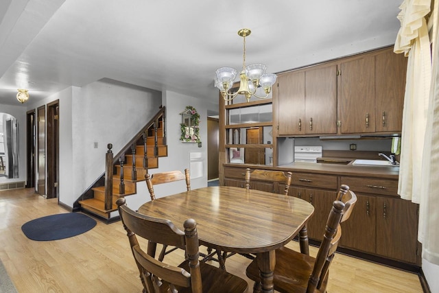 dining space featuring stairway, visible vents, light wood finished floors, arched walkways, and a notable chandelier