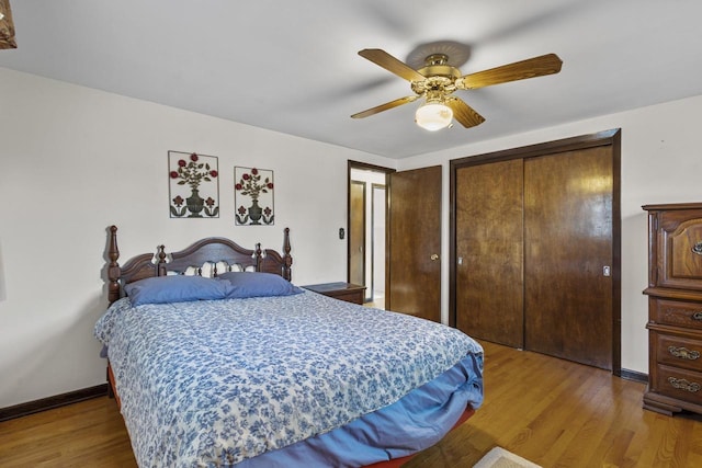 bedroom with a ceiling fan, wood finished floors, baseboards, and multiple closets