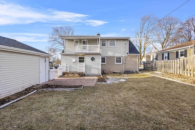 rear view of property featuring a patio, a balcony, a yard, and fence