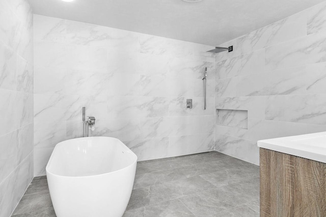 bathroom featuring vanity, tile walls, a freestanding tub, and tiled shower