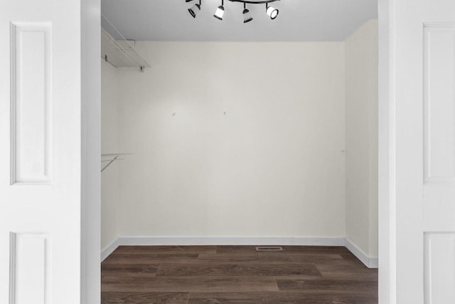 spacious closet featuring dark wood finished floors