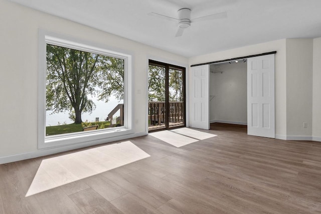 unfurnished room featuring ceiling fan, baseboards, and wood finished floors