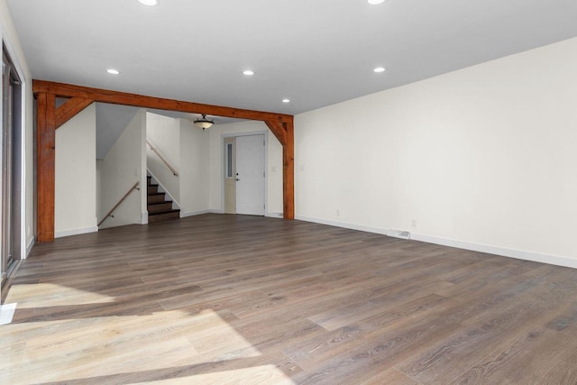 unfurnished living room with recessed lighting, stairs, baseboards, and wood finished floors