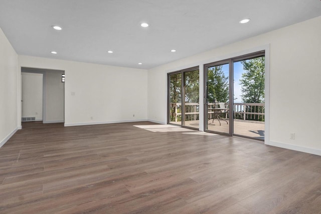 empty room featuring recessed lighting, baseboards, and wood finished floors